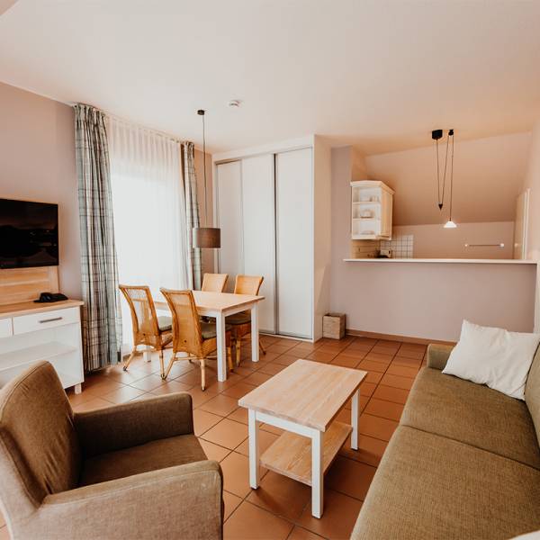 Der Wohnbereich mit Esstisch und kleiner Küche in einer Suite im Hotel Hüttmann.