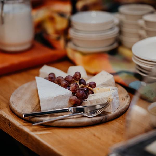 Nahaufnahme einer kleinen Käseplatte dekoriert mit roten Weintrauben im Hotel Hüttmann.