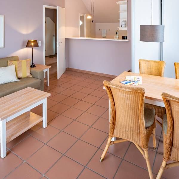 Der Wohnbereich mit Esstisch und kleiner Küche in einer Suite im Hotel Hüttmann auf Amrum.