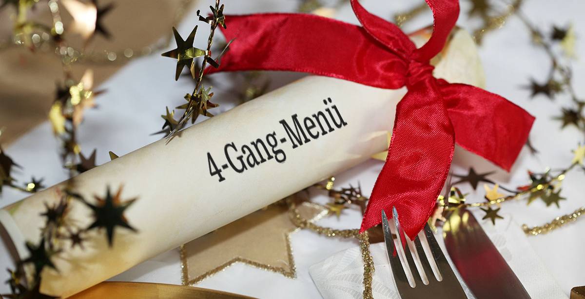 Ein weihnachtlich dekorierter Tisch mit Menürolle für ein festliches 4-Gang-Menü im Hotel Hüttmann