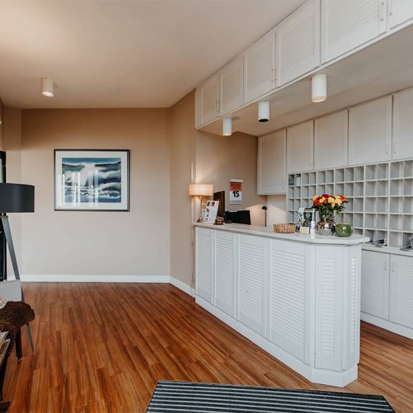 Die Rezeption in weiß und dunklem Holzboden im Hotel Hüttmann.