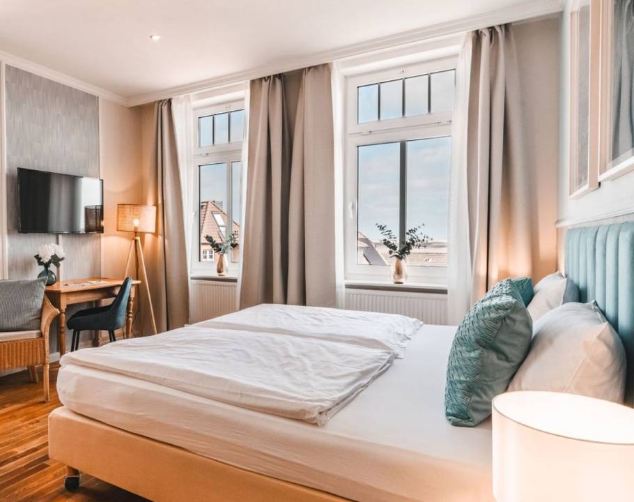 Ein gemütliches Doppelbett in einem Schlafzimmer in einer Ferienwohnung in Norddorf auf Amrum.