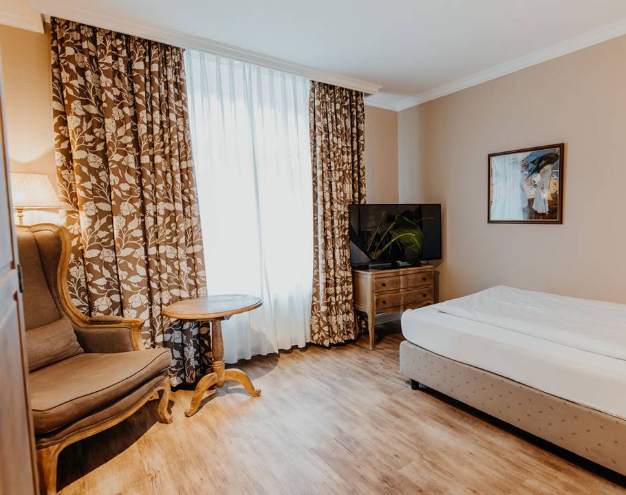 Ein Einzelzimmer mit Fernseher und Sitzgelegenheit in einer Ferienwohnung in Norddorf.