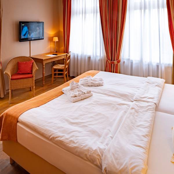 Ein gemachtes Doppelbett in einem Standard Doppelzimmer im Hotel Hüttmann.