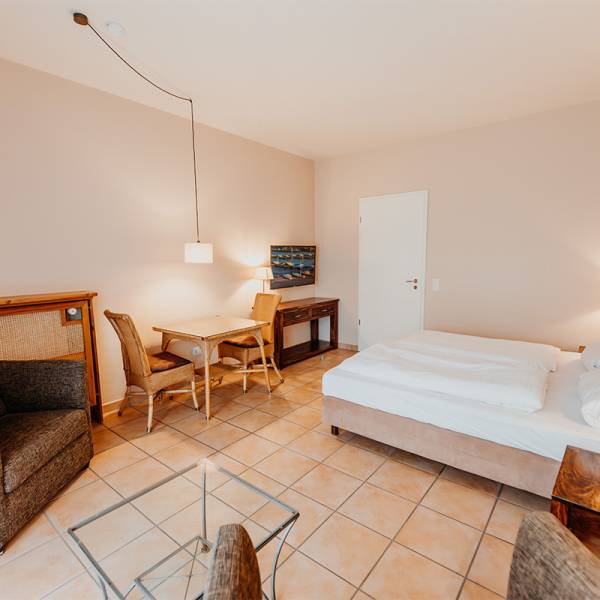 Ein Superior Doppelzimmer mit kleinem Esstisch im Hotel Hüttmann auf Amrum.