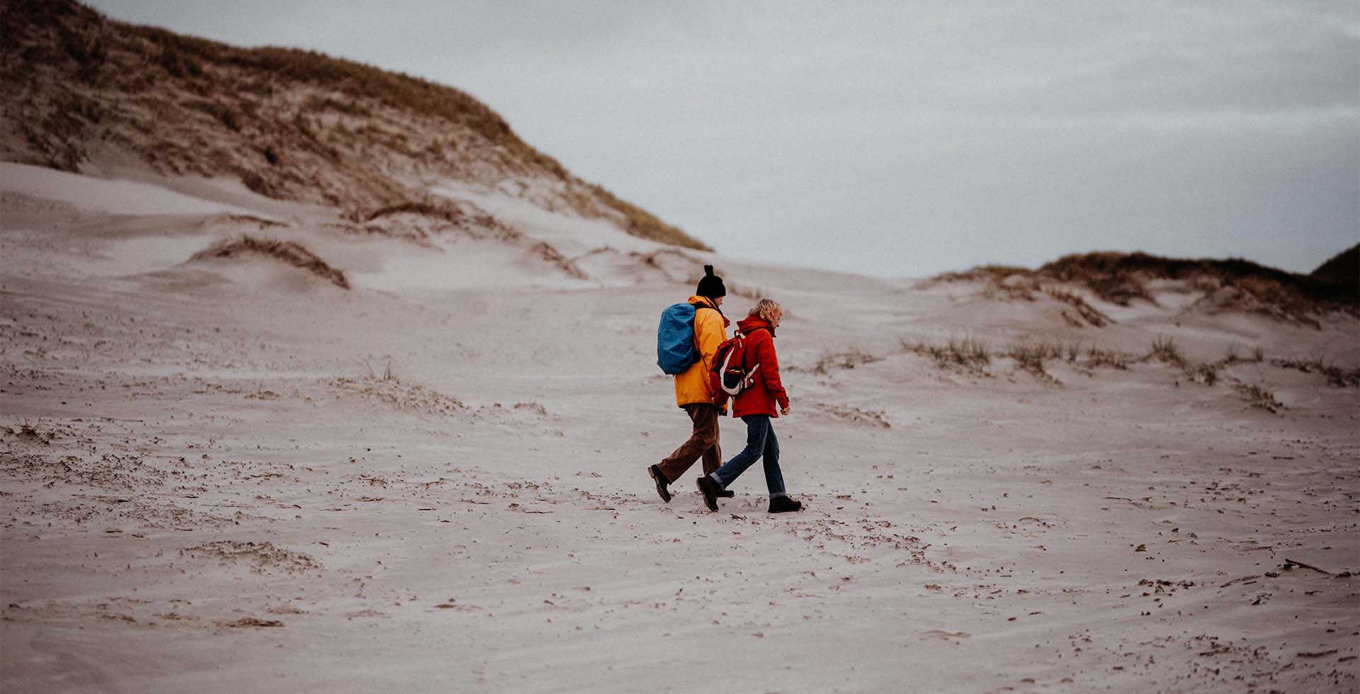 Ein Paar in wetterfester Kleidung bei einem Ausflug an einem der Strände von Amrum.